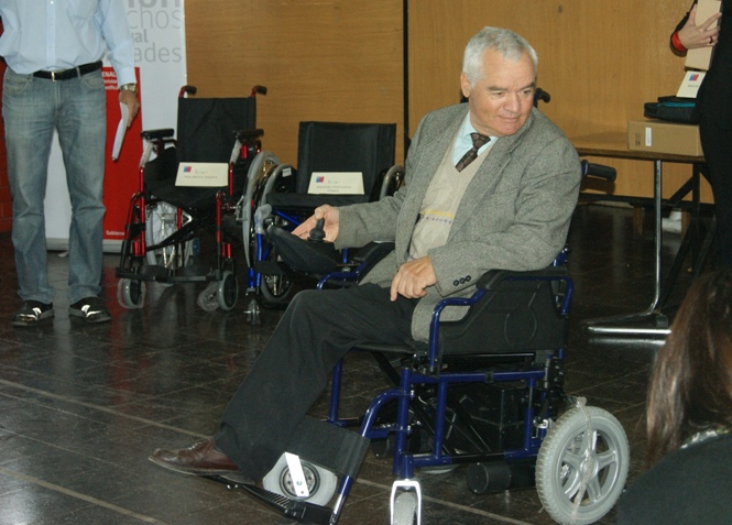 Persona con discapacidad en silla eléctrica entregada por Senadis.
